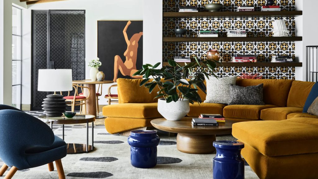 Stylish living room with mustard sofa, modern art, and navy blue accents.