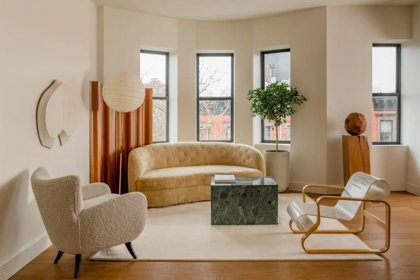 Modern living room with minimalist furniture and large windows.